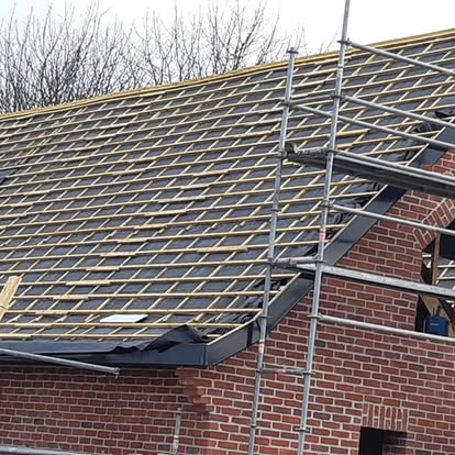 Réseau de liteaux posé sur une toiture en rénovation, avec échafaudage.