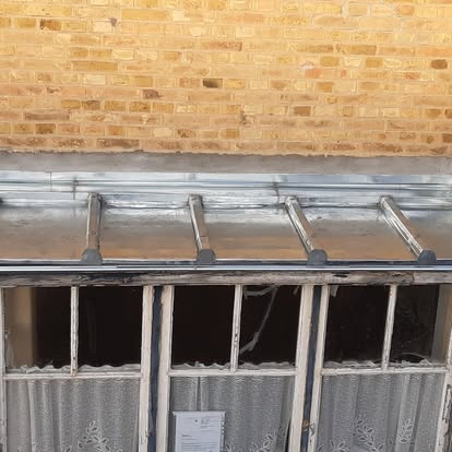 Détail d'un élément métallique de rive installé au-dessus d'une fenêtre.